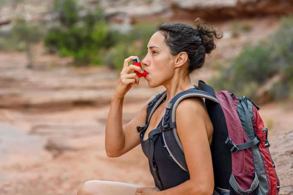 a woman using an inhaler during an asthma attack
