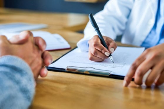 Insurance professional reviewing a health insurance application with a client applying for international health insurance