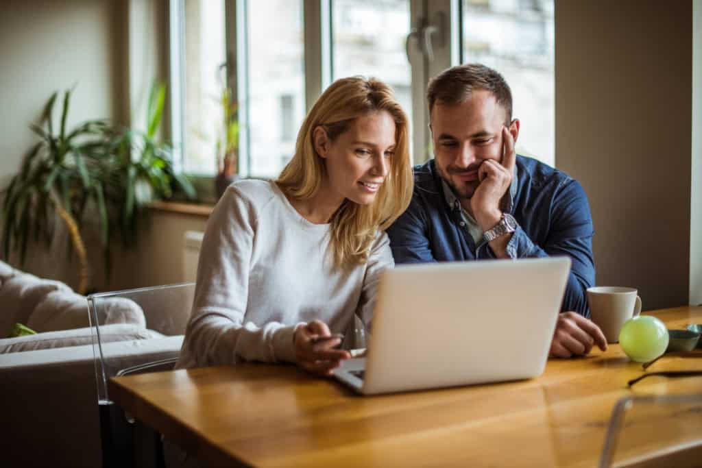 a couple checking maternity insurance options on their laptop