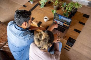 a happy couple at home booking a trip online