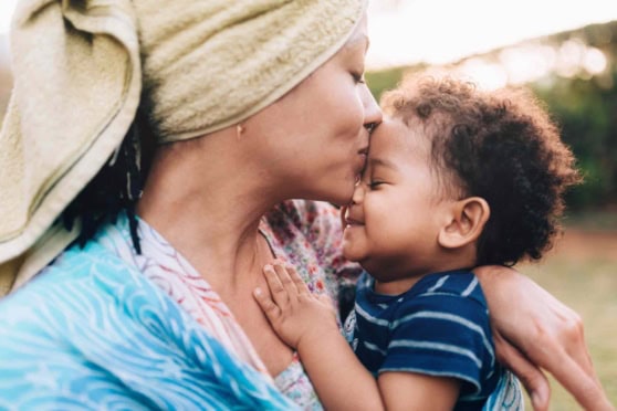 A mother and her child share a tender moment outdoors, emphasizing the importance of reliable health insurance for international citizens and families.