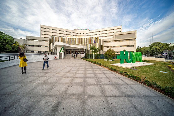 Healthcare facility with modern architecture, welcoming entrance, and green landscaping, representing international health insurance options for global citizens.