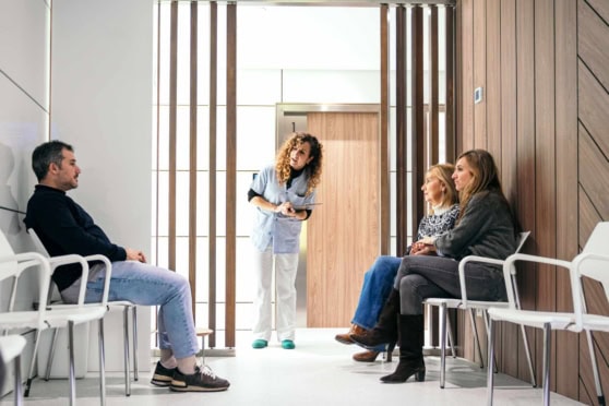 Healthcare professional speaking with patients in Spain, highlighting access to medical care through health insurance in Spain.