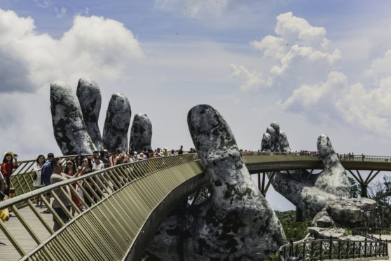 Discover the iconic Hand Bridge in Vietnam, showcasing massive stone sculptures of hands supporting a walkway. A must-see cultural site attracting tourists for its unique design and scenic surroundings.