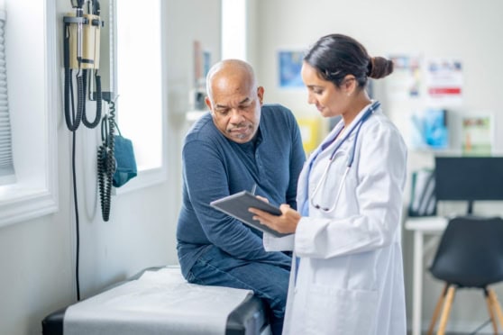 Patient discussing health insurance with a doctor at a medical clinic, highlighting the importance of coverage for non-US citizens