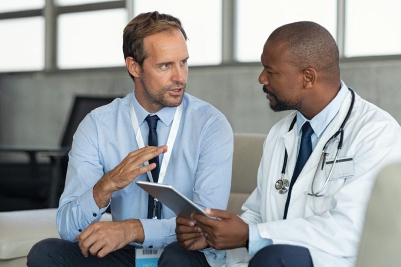 Doctor talking to person about paperwork