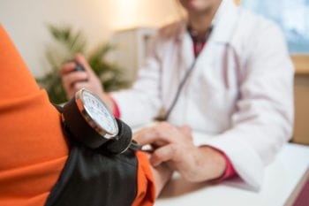 Doctor in Finland taking a patient's blood pressure