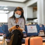 Woman with mask dealing with travel insurance requirements