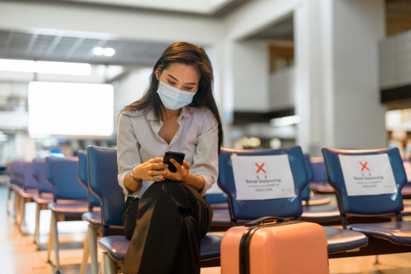 Woman with mask dealing with travel insurance requirements