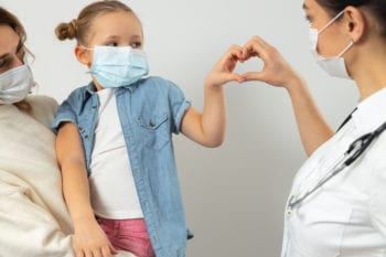 hungarian doctor making heart with with child out of hands and mom