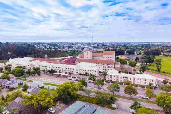 Aerial view of a city with green spaces, buildings, and a partly cloudy sky, illustrating international travel and global insurance coverage options.