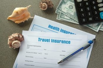 travel insurance document with pen and currency