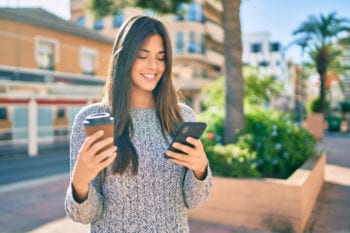 Portuguese expat in city center with cell phone and coffee