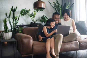 malaysian family sitting on sofa with laptop