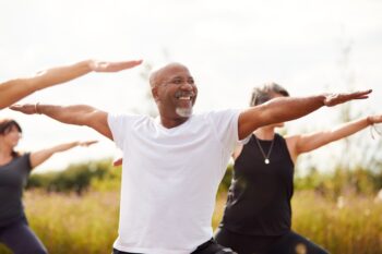 outdoor-yoga a smiling man enjoying an outdoor yoga class in one of the healthiest countries in the world