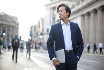 Elegant businessman walking in the street, wearing a blue suit International businessman using GlobalFusion insurance plan