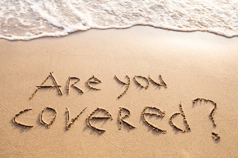 "Are you covered?" written in sand on the beach