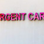 Red Urgent Care sign on beige wall