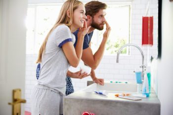 Couple in pajamas doing their skin care routine in the bathroom