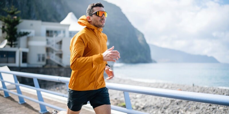 a man jogging in the sun, wearing UV protection sunglasses, one of the best skin care tips for expats