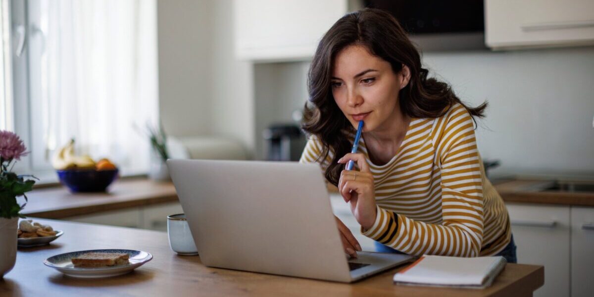 a woman applying for a Schengen visa on her laptop at home