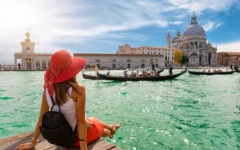 Female tourist looking at the Basilica di Santa Maria della Salute and Canale Grande in Venice, Italy