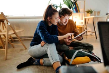 a couple planning where to go on vacation during hurricane season, while researching hurricane travel insurance