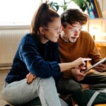 a couple planning where to go on vacation during hurricane season, while researching hurricane travel insurance