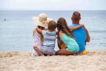 a family sitting on a beach in Mexico, one of the best countries for American families to move to in 2025