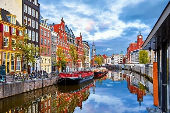 2. Scenic city canal with colorful historic buildings, boats, and reflections on water, showcasing urban charm and waterfront life in a European cityscape.
