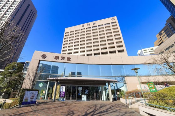 Bright, contemporary office building in a busy cityscape, featuring large glass windows and surrounded by trees, representing international insurance services.