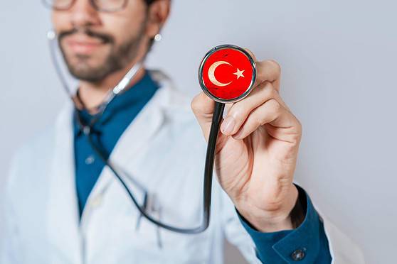 A healthcare professional holding a stethoscope with Turkey's flag on the chest piece, symbolizing international health coverage and medical insurance solutions for global travelers and expatriates.
