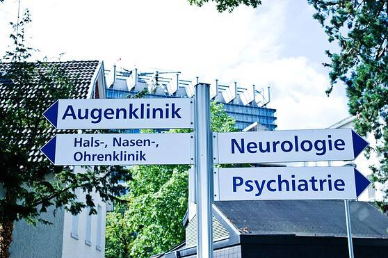 High-quality image of directional signs leading to medical specialties including eye, ENT, neurology, and psychiatry, emphasizing healthcare options.