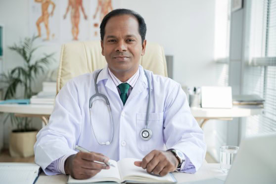 A professional doctor sitting confidently at his desk, ready to provide healthcare solutions, representing reliable international health insurance services.