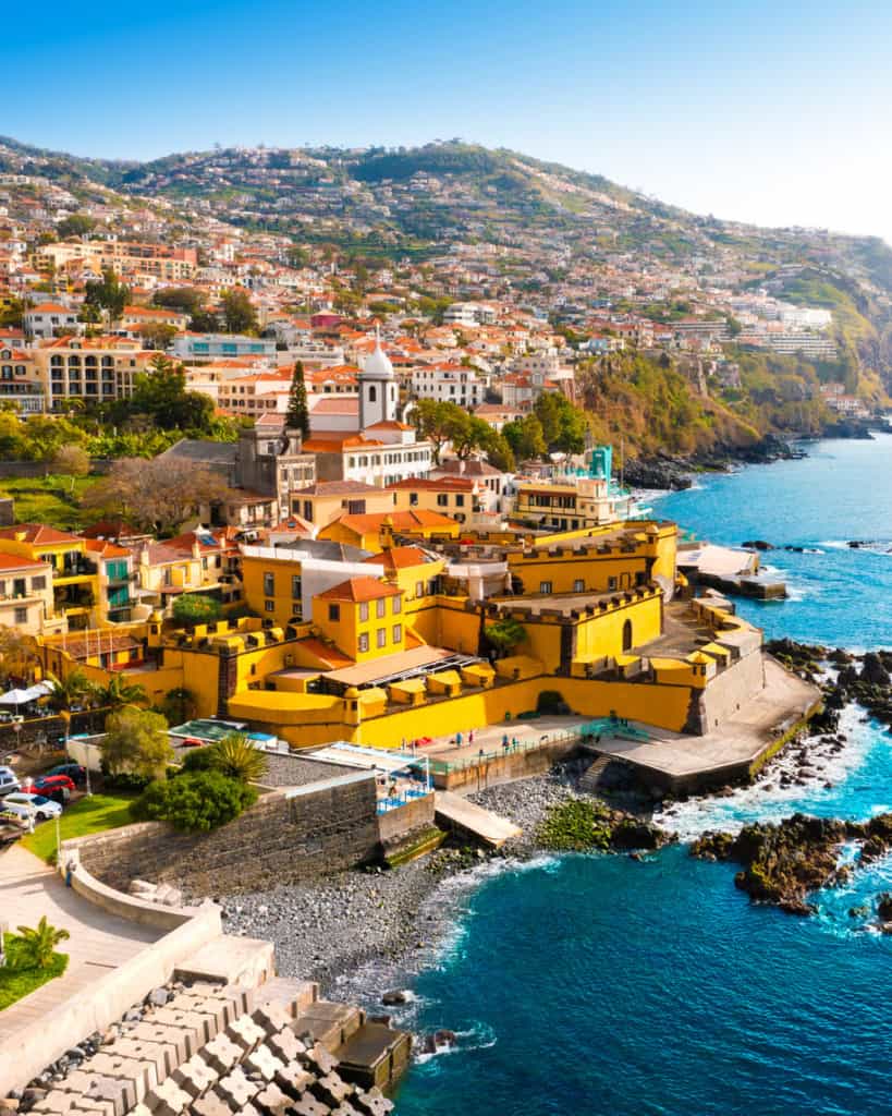 A vibrant coastal town in Costa Rica featuring colorful buildings, historic architecture, and scenic ocean views, perfect for expatriates seeking international insurance options.