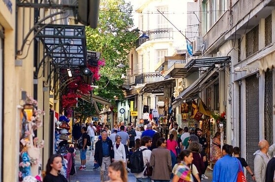 Bustling urban shopping street filled with pedestrians, boutique stores, and colorful storefronts, capturing lively city life and diverse crowd interactions.