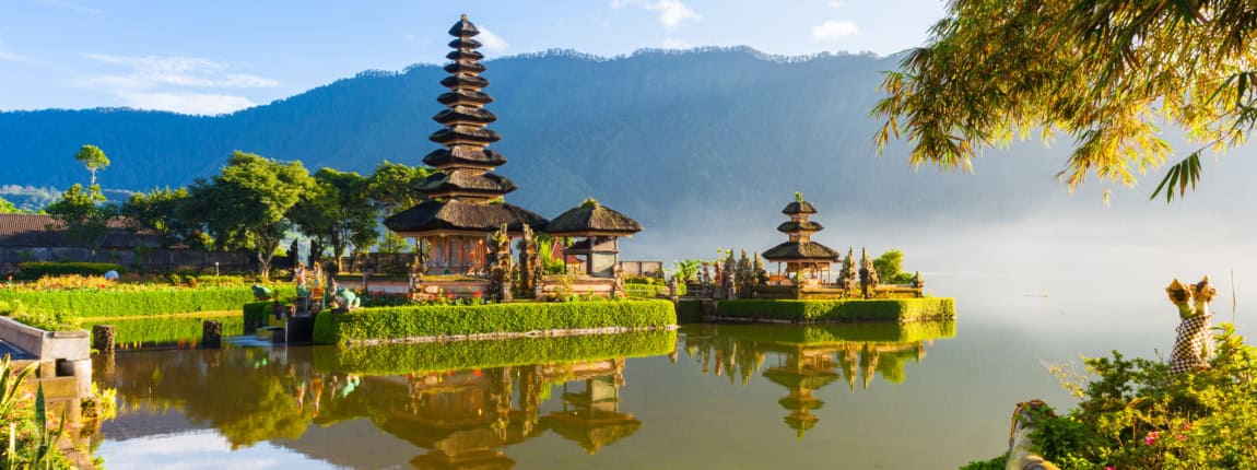 Beautiful island temple with traditional architecture and peaceful water surroundings, emphasizing safety and insurance for international travelers and expatriates.