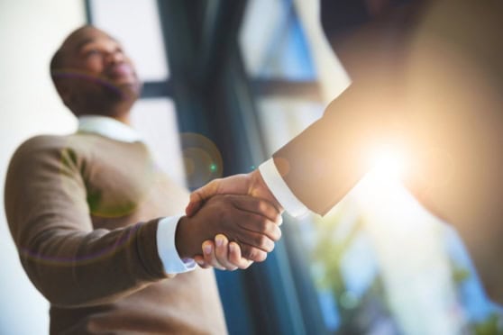 A professional handshake between two businesspeople symbolizes international insurance solutions for global citizens.