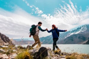 Hiking couple in mountains near a lake, enjoying outdoor adventure and nature at ICI 2025 event.