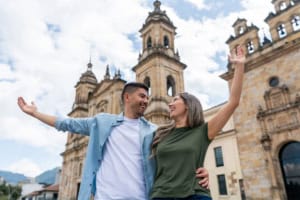 Happy couple enjoying time outdoors in front of historic cathedral during daytime, celebrating diversity and cultural heritage, travel and tourism, and community connection.