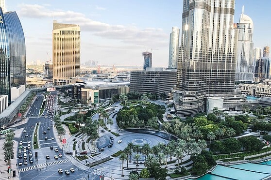 Aerial view of Dubai downtown with tall buildings, roads, and landscaped areas, highlighting international city life and infrastructure.