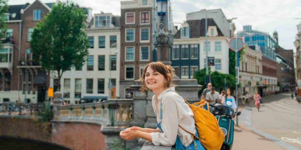 Comprehensive coverage for international travelers; a woman moving abroad to Amsterdam
