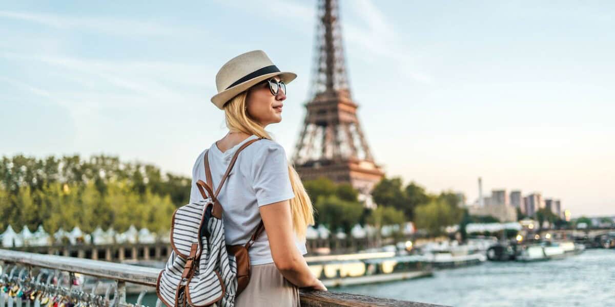 a woman admiring the Eiffel Tower in Paris, having purchased travel insurance for France