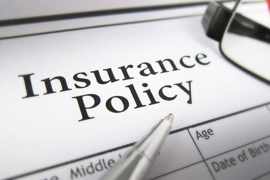 A close-up of an insurance policy form with a pen and glasses for international health coverage. Focus on the words "Insurance Policy," highlighting global insurance services.