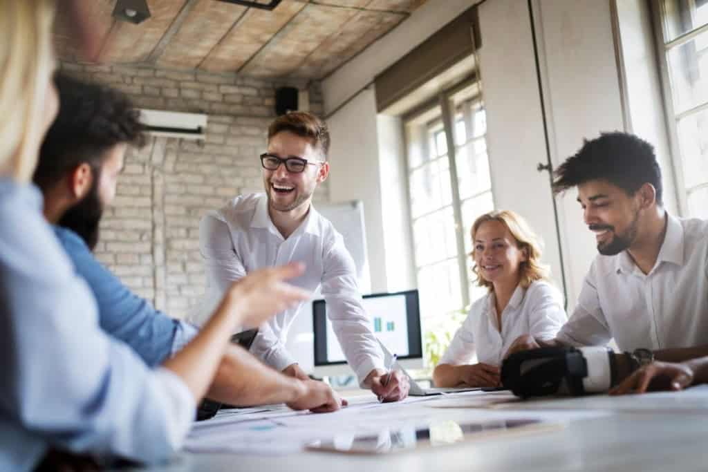 A diverse group of professionals collaborating around a table in a bright, modern office to provide international insurance solutions for global citizens.