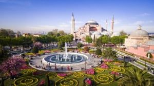 Historic Istanbul skyline with the Hagia Sophia and Sultanahmet Square, vibrant cityscape, popular tourist destination, iconic architecture, green landscape, floral gardens, fountain, cultural heritage, travel destination, Turkey.