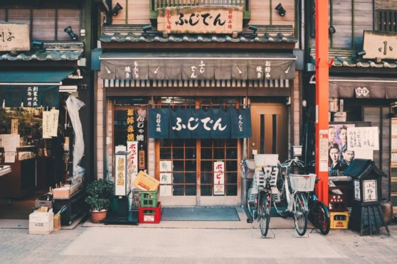 Japanese restaurant storefront with traditional signage, bicycles, and cultural decor, representing international travel and global cuisine.