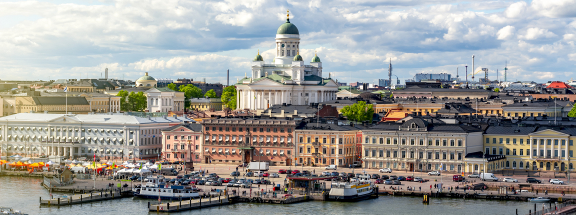 Vibrant Helsinki cityscape featuring the Helsinki Cathedral overlooking the harbor during daytime with a partly cloudy sky.