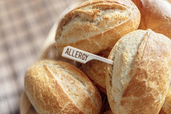 A close-up of freshly baked bread rolls with a small allergy warning flag indicating potential allergen risks. Perfect for illustrating allergy awareness and safe food practices.