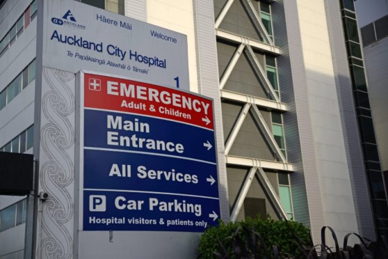 A large hospital sign pointing to emergency, main entrance, services, and parking at Auckland City Hospital.